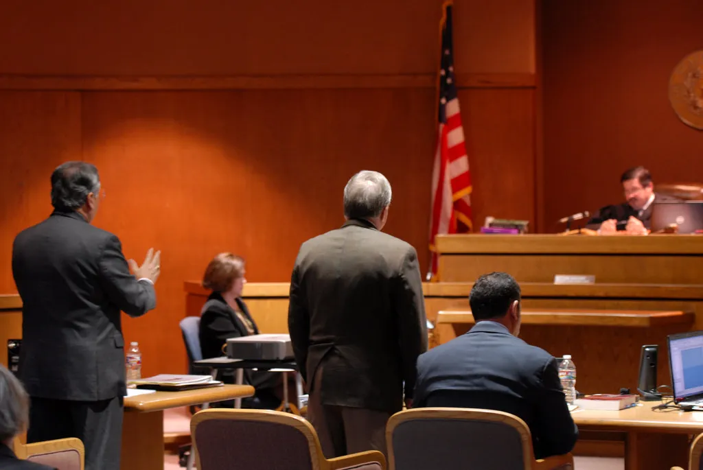 Courtroom scene with judge, attorneys, and defendants